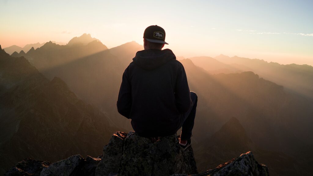 Man Looking at the sunrise over mountains